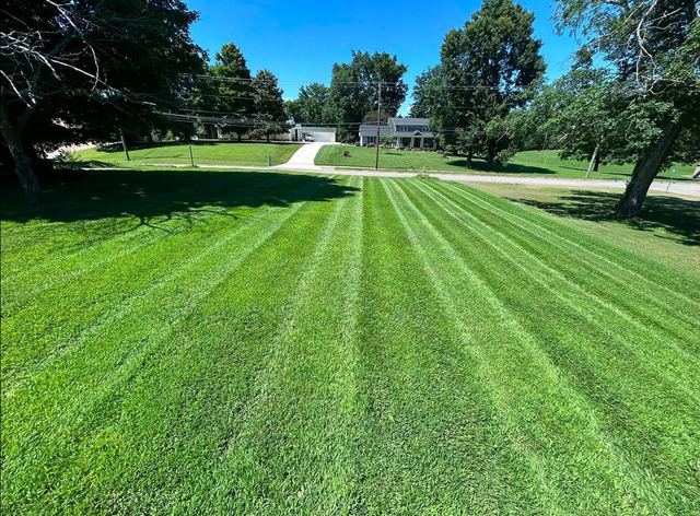 Striped lawn mowing on a large hillside property in southern Minnesota