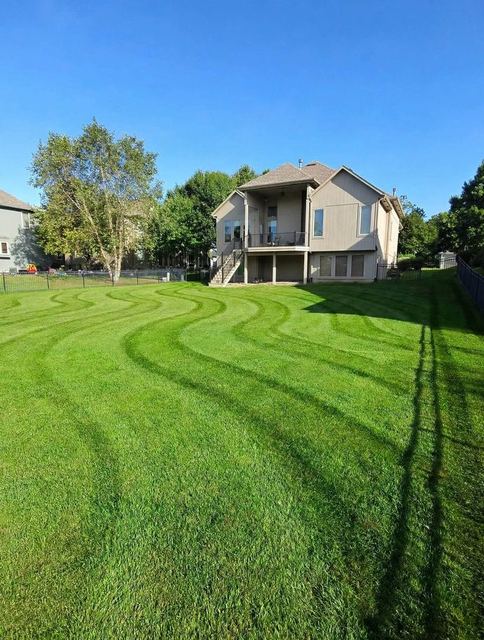 Curved striped lawn mowing pattern on a large Minnesota lawn